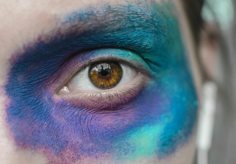 the eyes of an adult wearing blue and green makeup