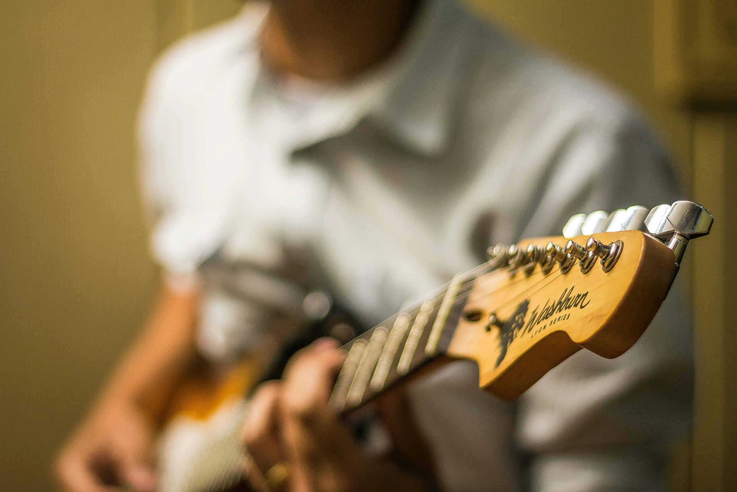 close up of person holding small electric guitar