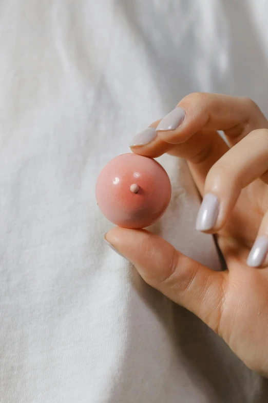 someone is holding a fake pink ball in their hands