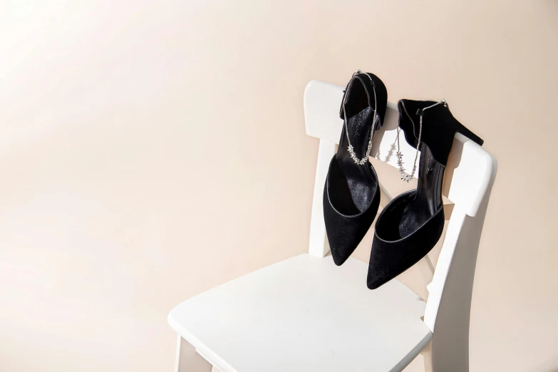 some black shoes are on a white chair