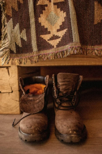 two pairs of old hiking boots in front of a rug