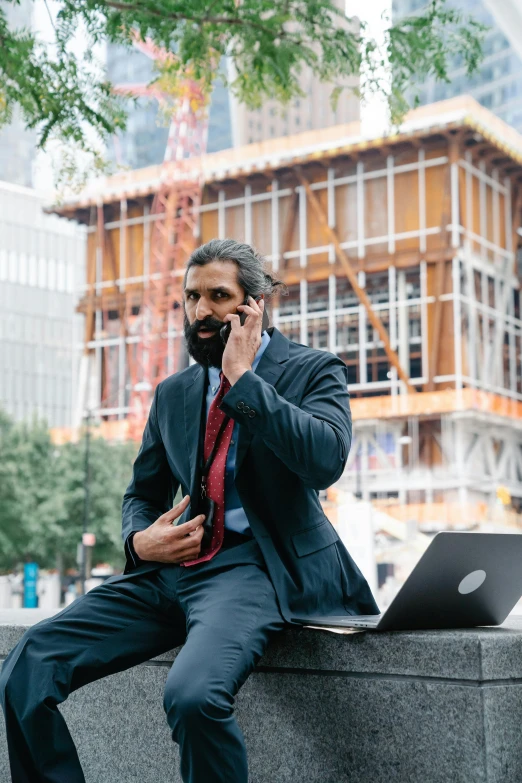 an african american man in a suit talks on his cell phone