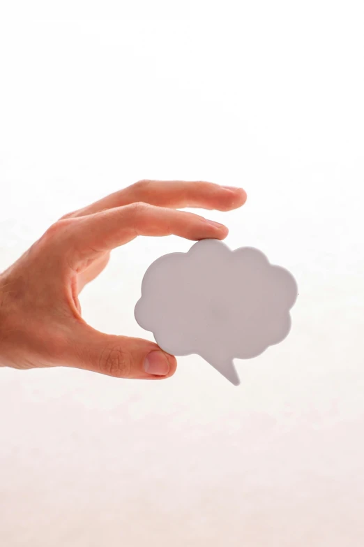 a person holding a gray speech bubble over a white backdrop