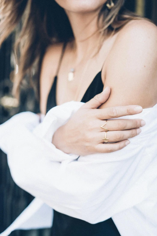 a woman wearing two gold rings around her finger