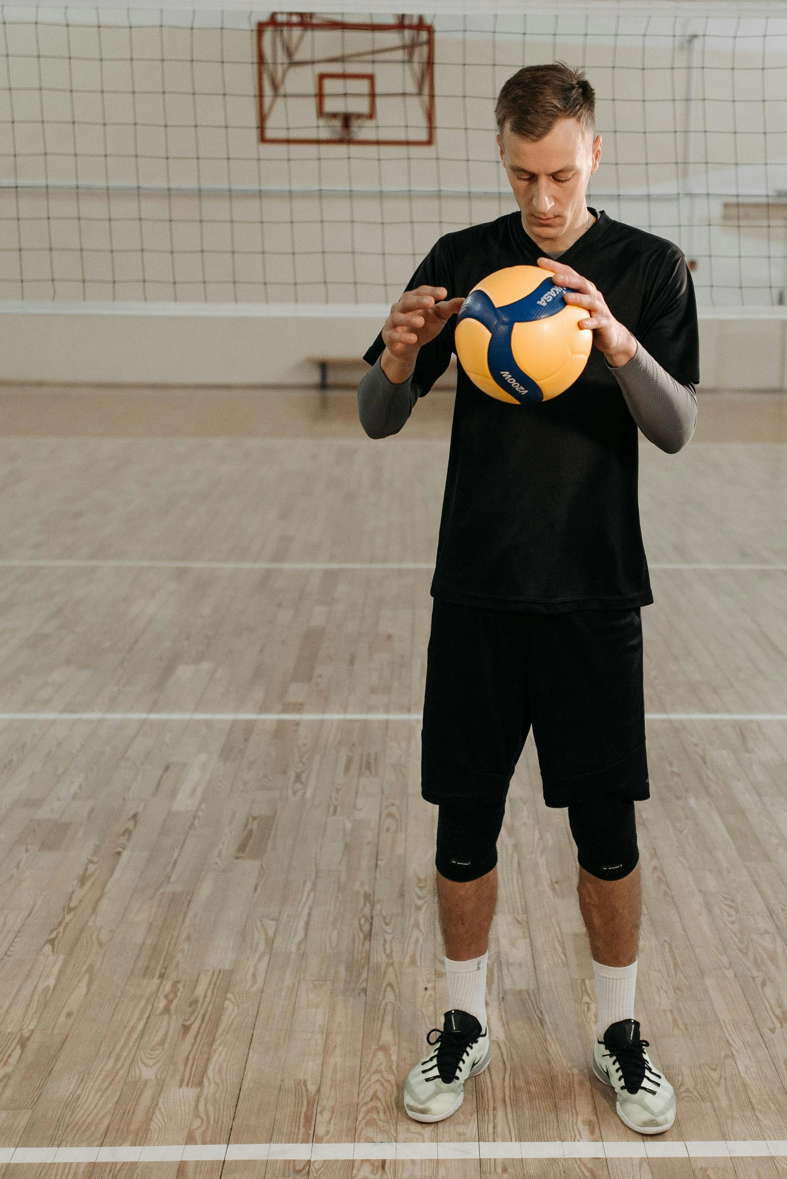 a man holding a ball while standing on a court