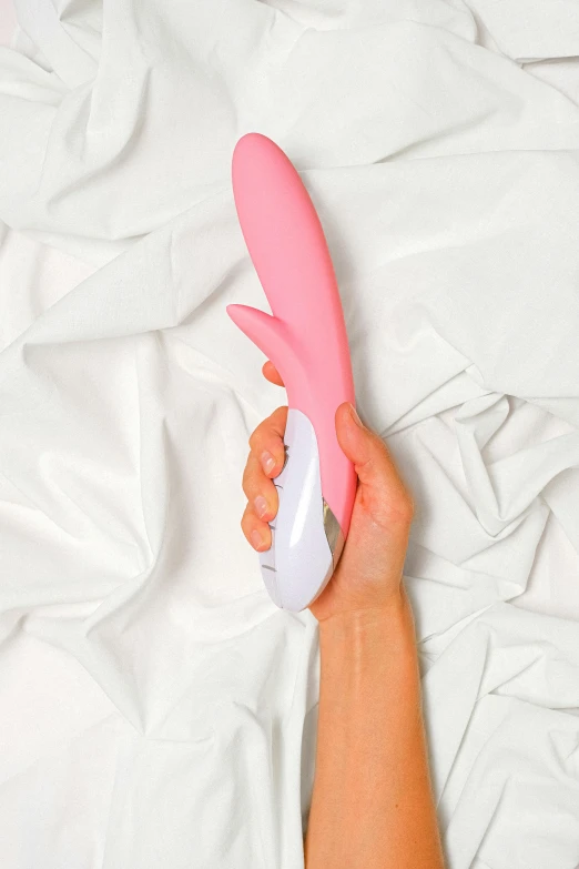 there is a hand holding a pink and white tooth brush