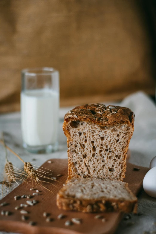 bread and grains on a board next to glass of water