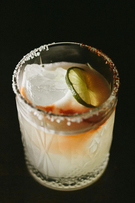 a drink with a lime wedge on it sitting on a table