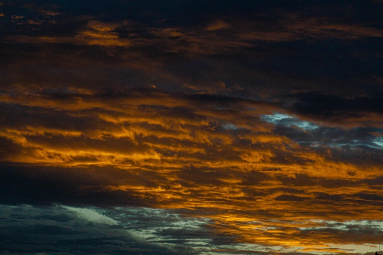 a picture of a setting sky with a plane flying in the distance