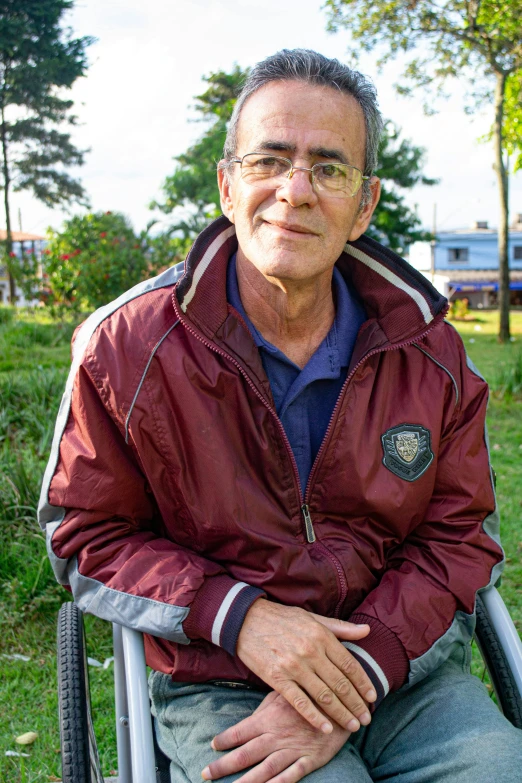 a man in a wheelchair with his arm on the side of his leg