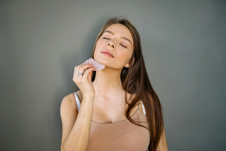 a beautiful young lady in a tan shirt laying her head on her hand