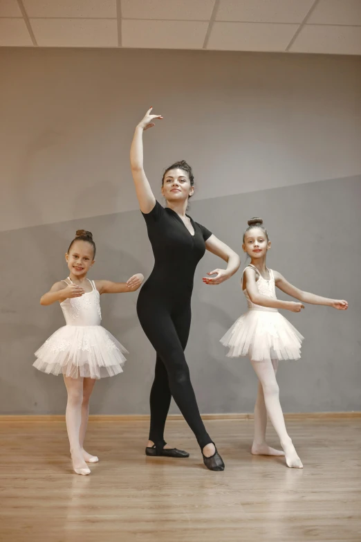 a group of ballet girls in black leotards standing around