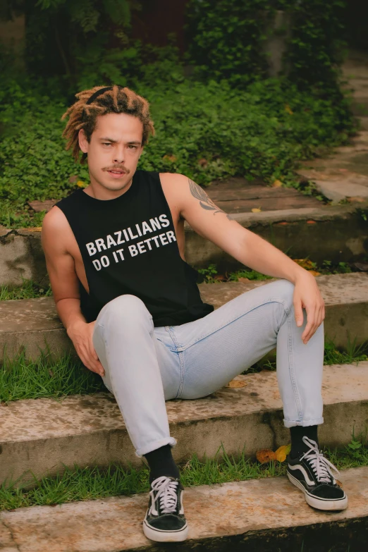 a young man with dreadlocks sitting on steps