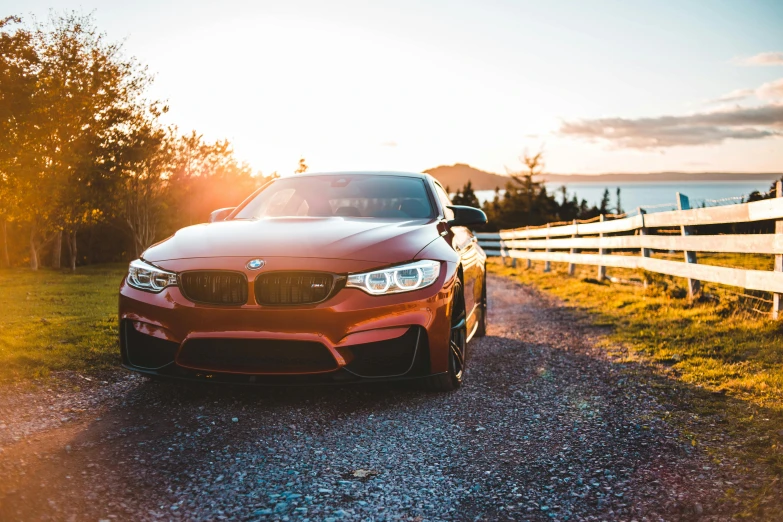 a car parked on a dirt road by some water