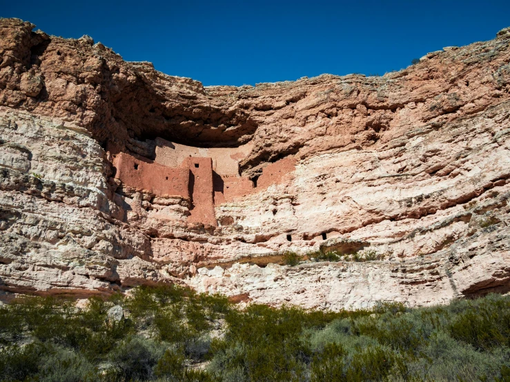 a large mountain has a cave with a rock wall