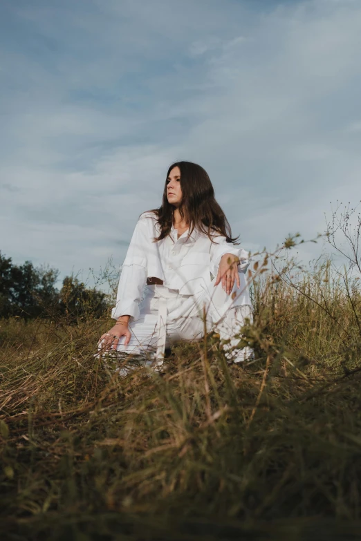 a woman sitting in the middle of a field