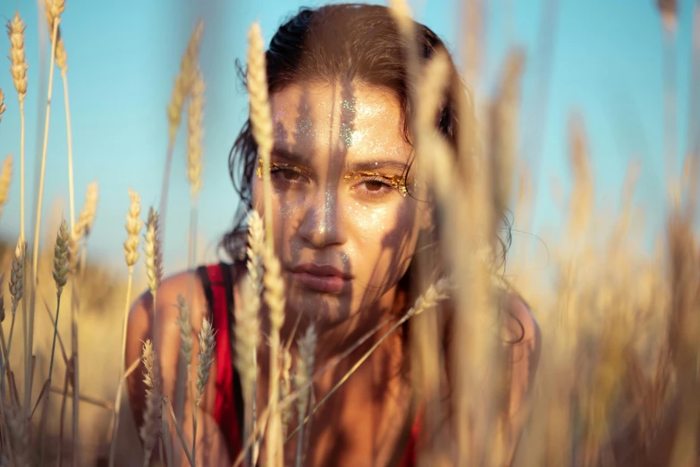 a girl standing in tall grass with eyes open