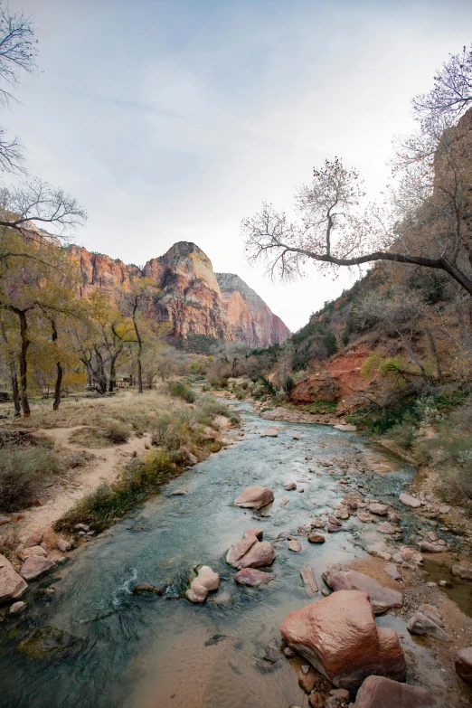 a river with rocks running through it next to a mountain