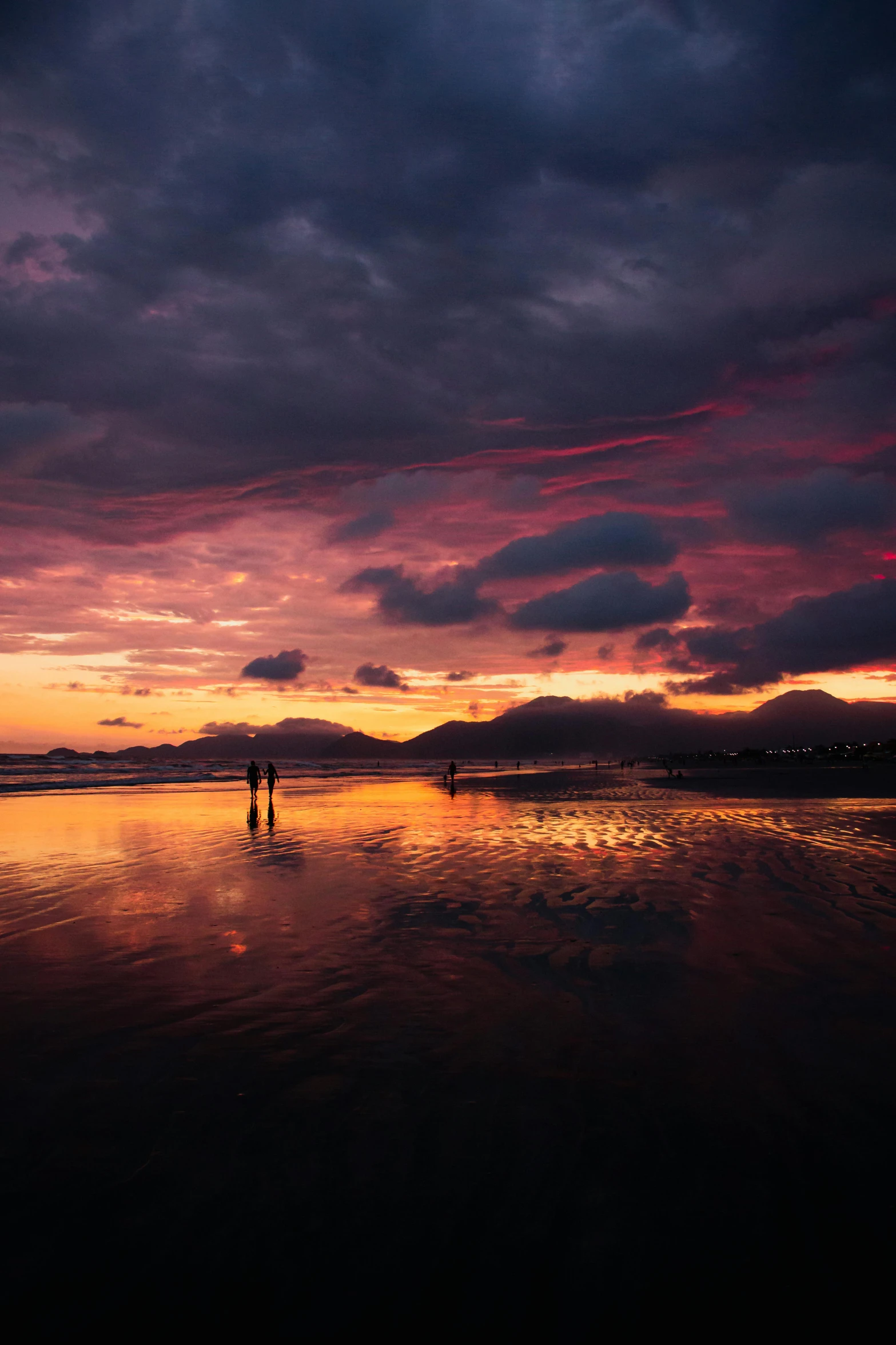 a sunset view with people standing in the water