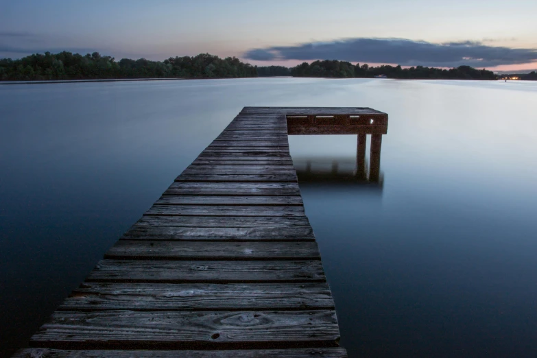 a wooden dock is on the water next to the ocean