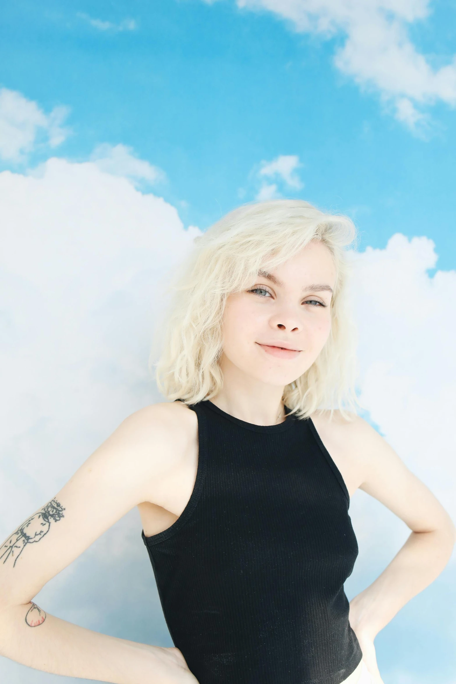 a white haired girl with a black shirt standing on the grass