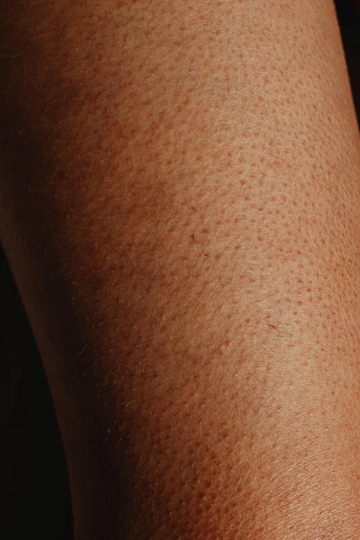 a close up view of someones skin as he holds a cell phone