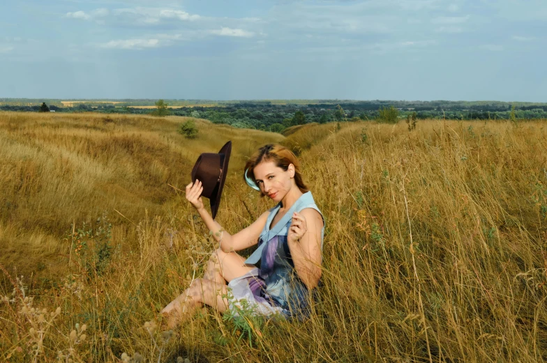 the young woman is posing on her hat