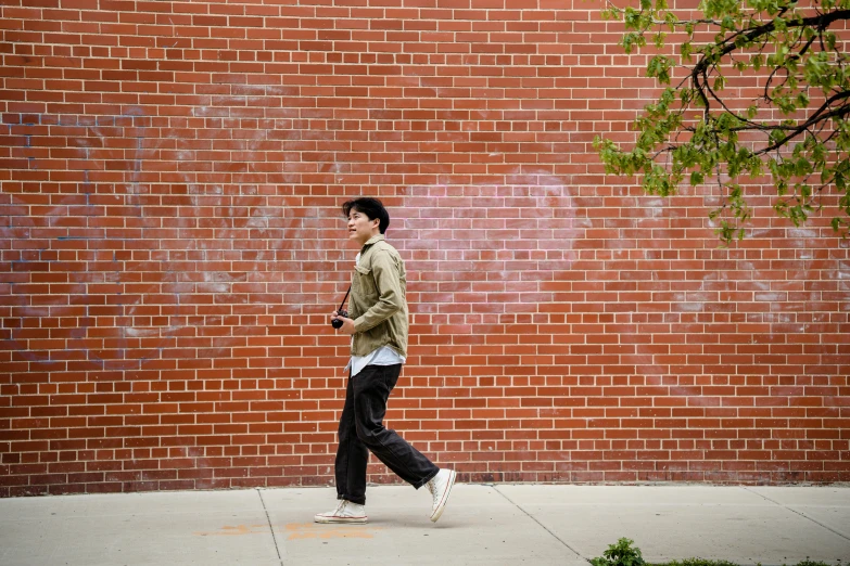 a person walking past a brick wall