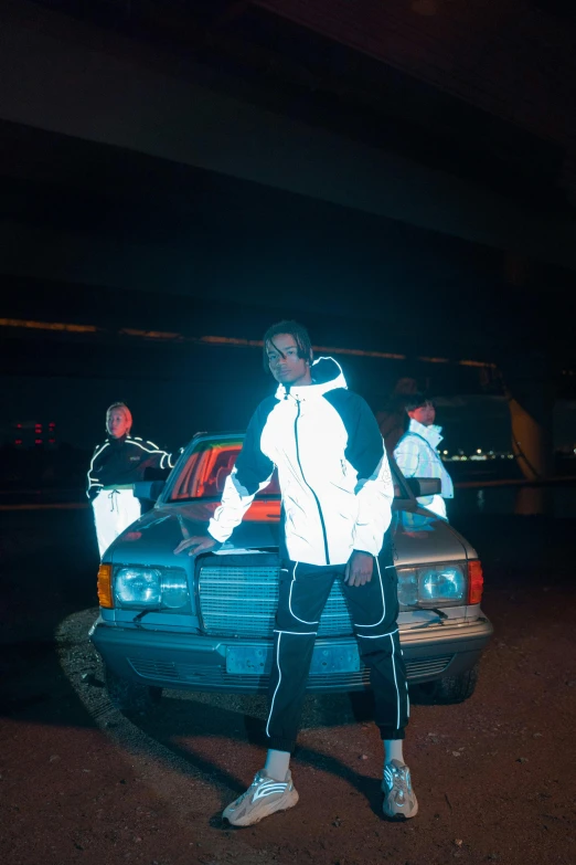 a man in a jacket standing next to his car