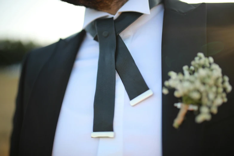 a black tie and white shirt are worn by the groom