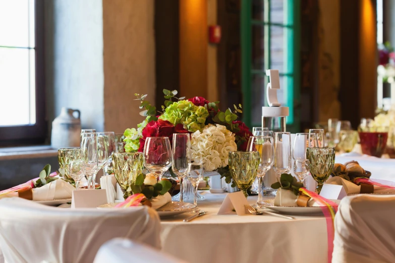 white and red flowers are sitting on the table in a banquet