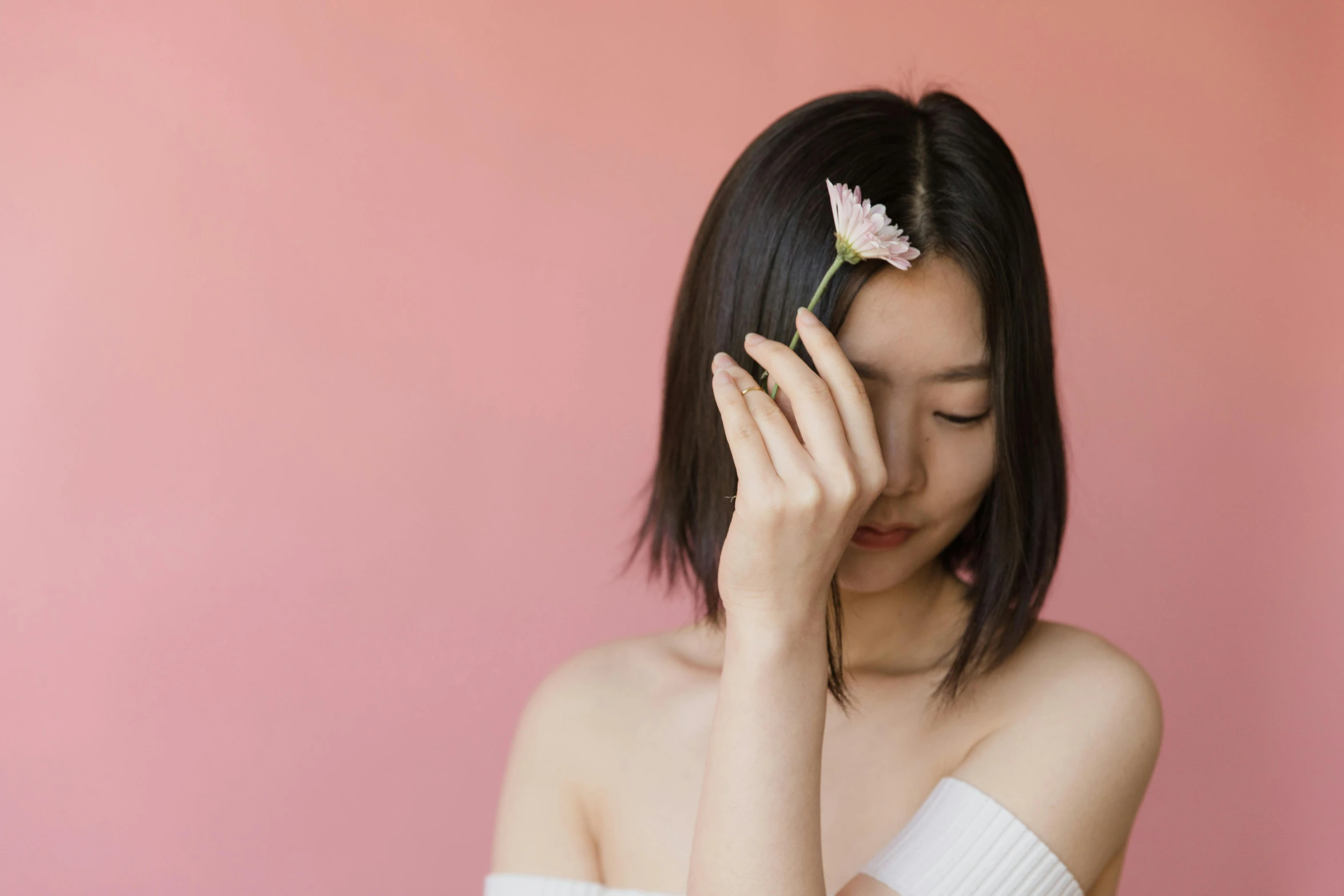 a girl is holding a flower in her hand