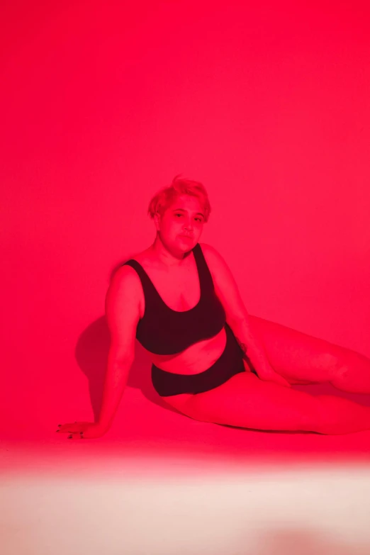 a woman in black and red sitting on the floor