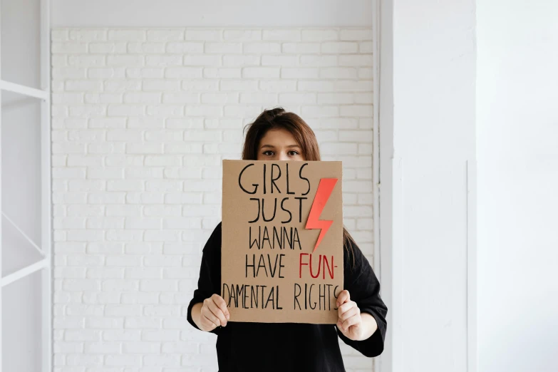 a woman holding up a sign reading girls just wanna and have fun metal night