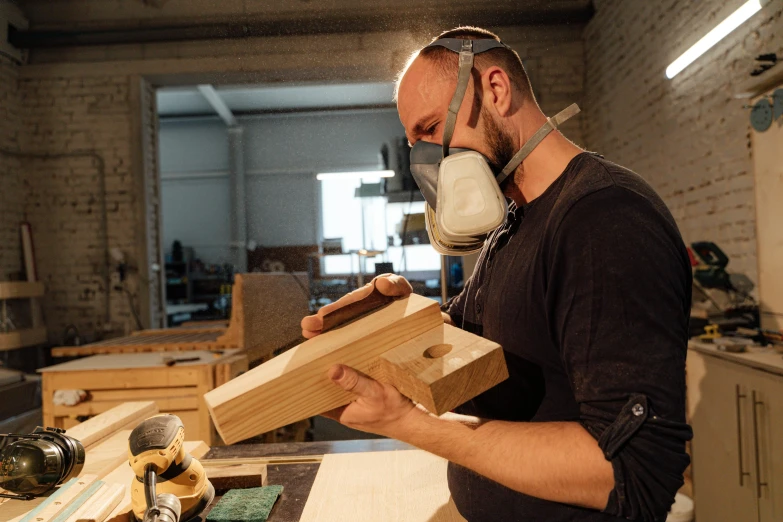 a man working in a woodworking workshop using an angle tool