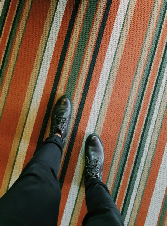 man in black shoes on multicolored rug