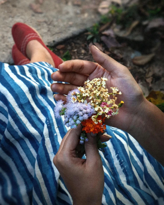 a woman holds flowers from her bouquet as she looks at it