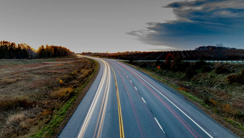 the empty road is leading to some houses