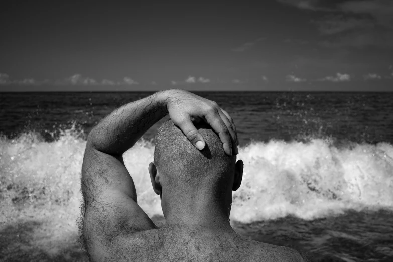 a man in the surf has his arm behind his head