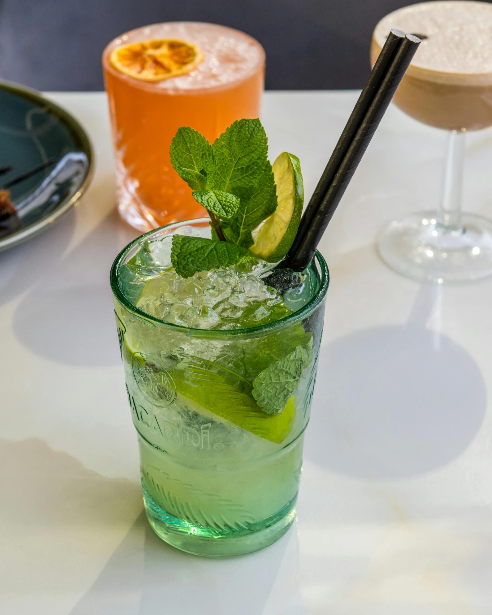 a glass of cocktail with lime and mint