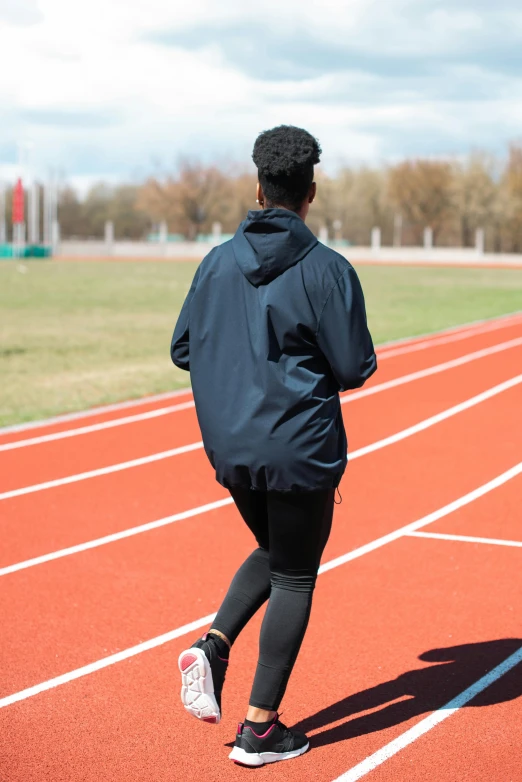 a man walking across a race track towards another