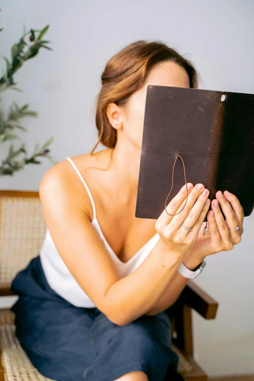 a woman sitting down on a couch holding soing