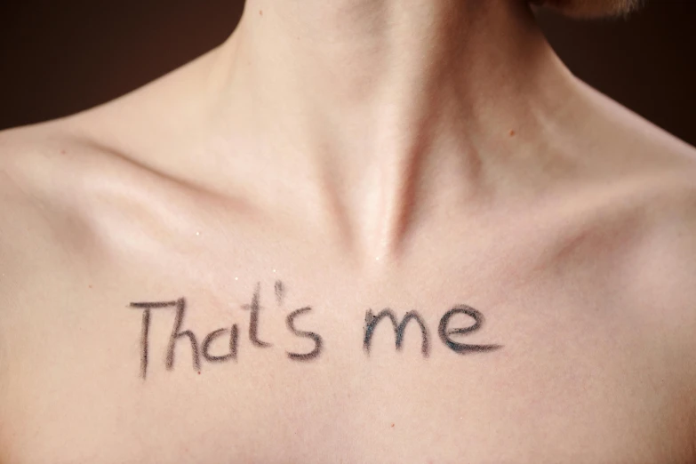 a shirtless woman's shoulder that reads, that's me