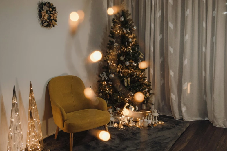 a chair, christmas tree, and small decorative items are arranged in an otherwise cluttered living area