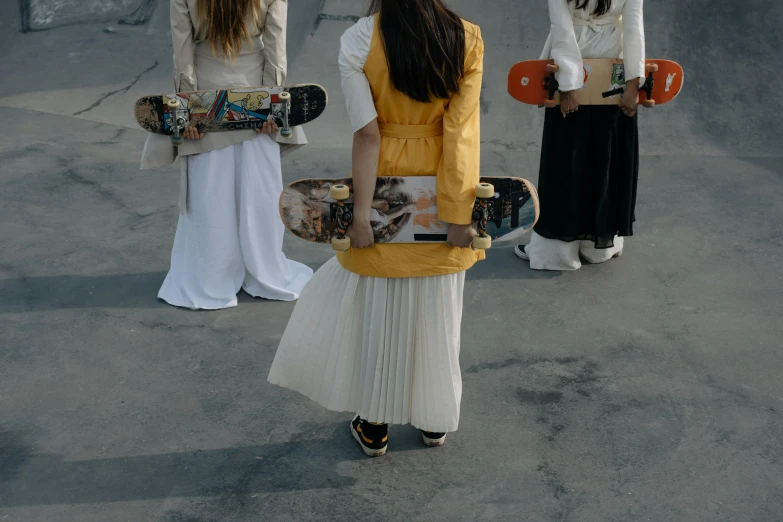 three people standing next to each other with skateboards