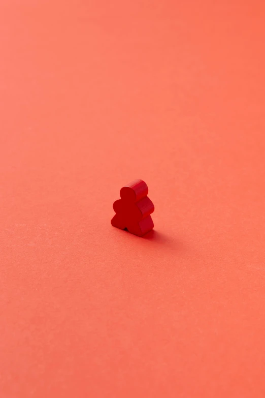 small piece of red plastic material with two smaller pieces on it