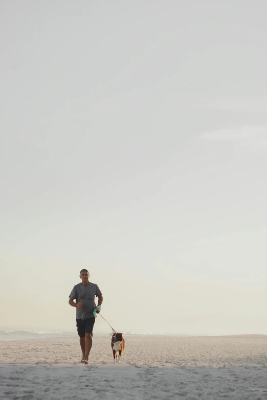 a man running with a small dog on a leash