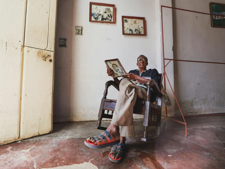 a woman sitting on a chair and reading a newspaper