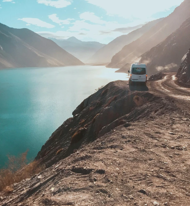 the van is parked on the side of a mountain road