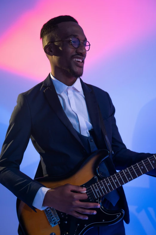 man in suit and tie holding electric guitar